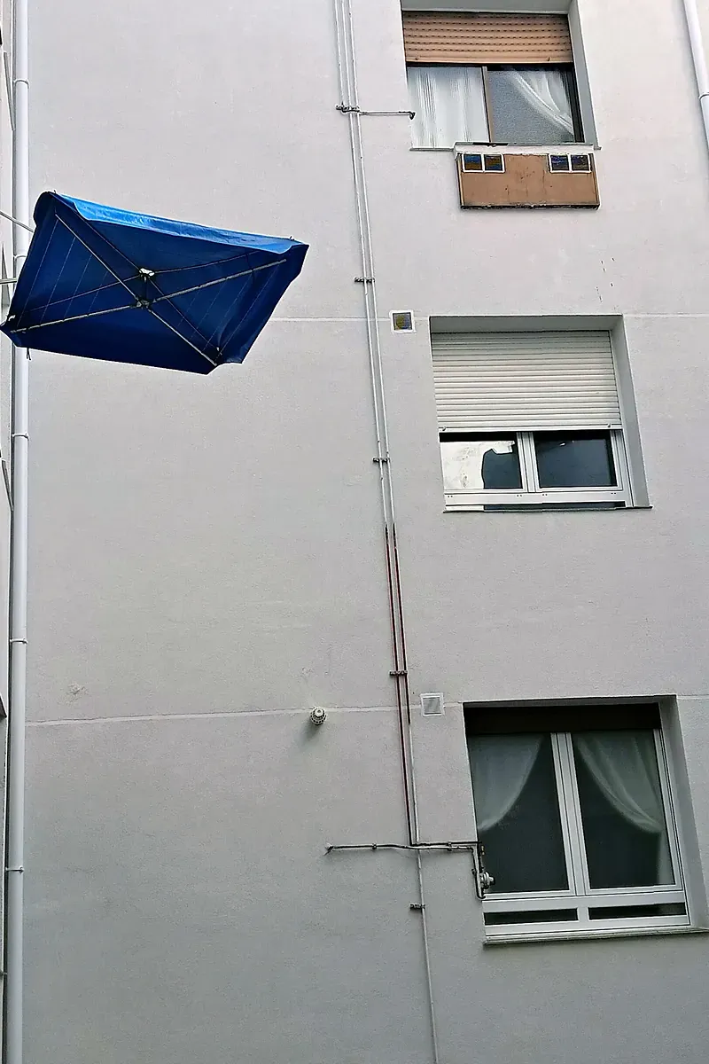 Fachada de patio interior tras la obra, con SATE y carpinterías de PVC nuevas, en Estación de Basurto, 12 (Bilbao)
