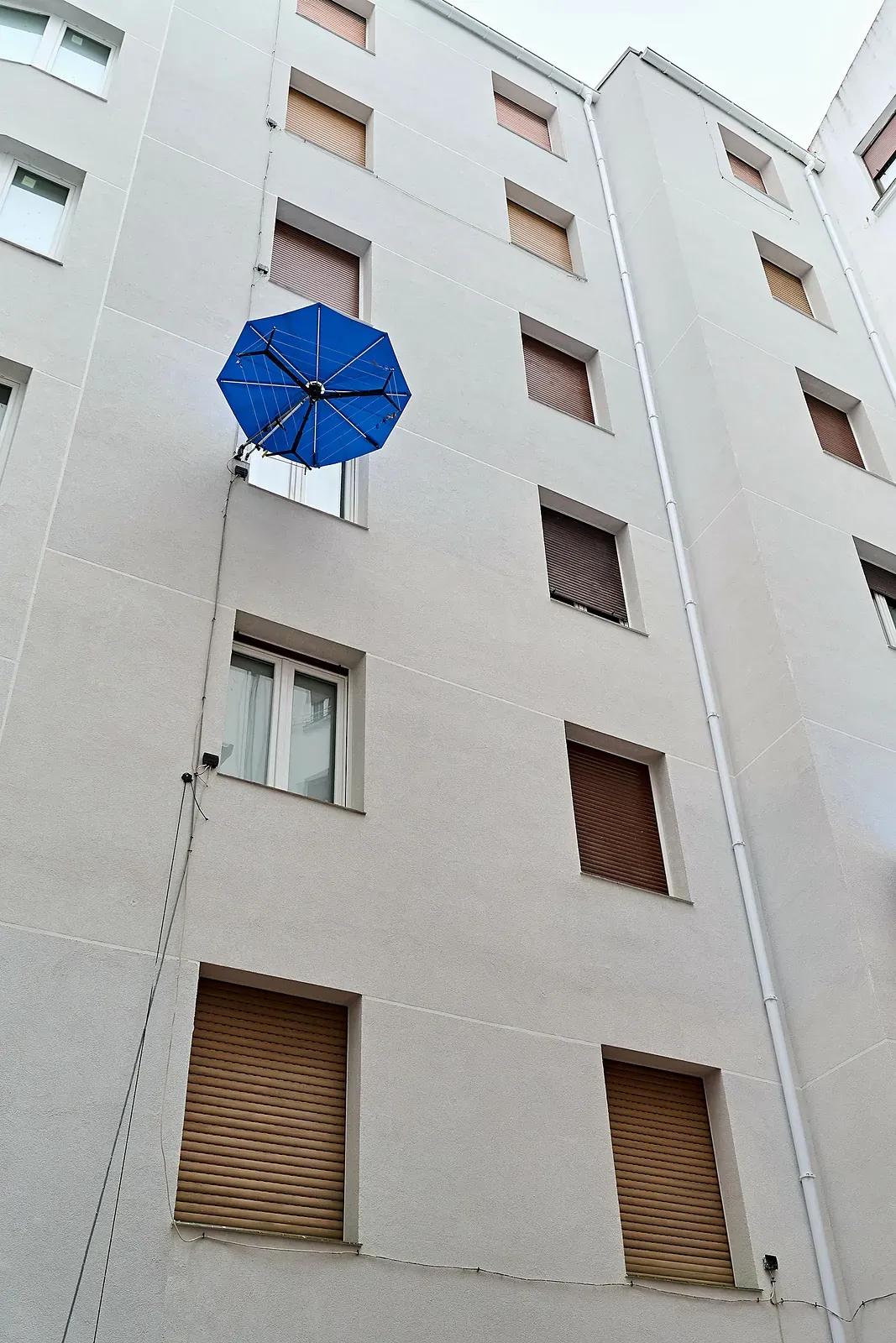 Fachada de patio con SATE terminado en revoco claro y ventanas con persianas, en Estación de Basurto, 12 (Bilbao)